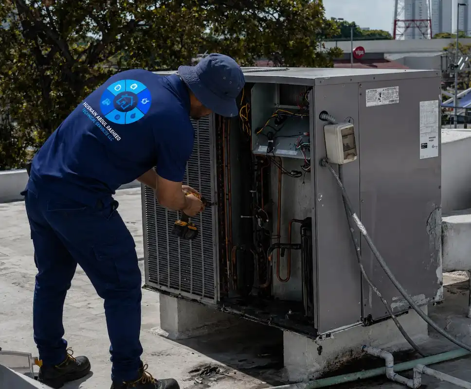 AC technician servicing central air handling unit on Dubai villa rooftop