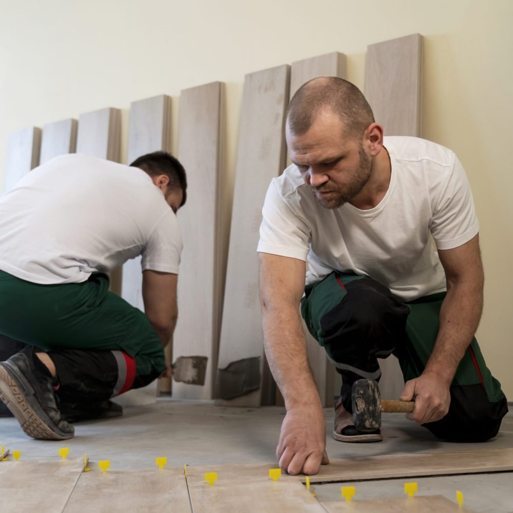 full-shot-workers-tiling-floor-indoors (1)