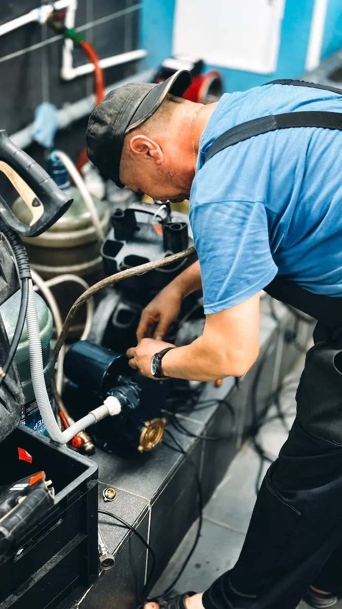 Technician servicing commercial-grade plumbing pump equipment in a facility