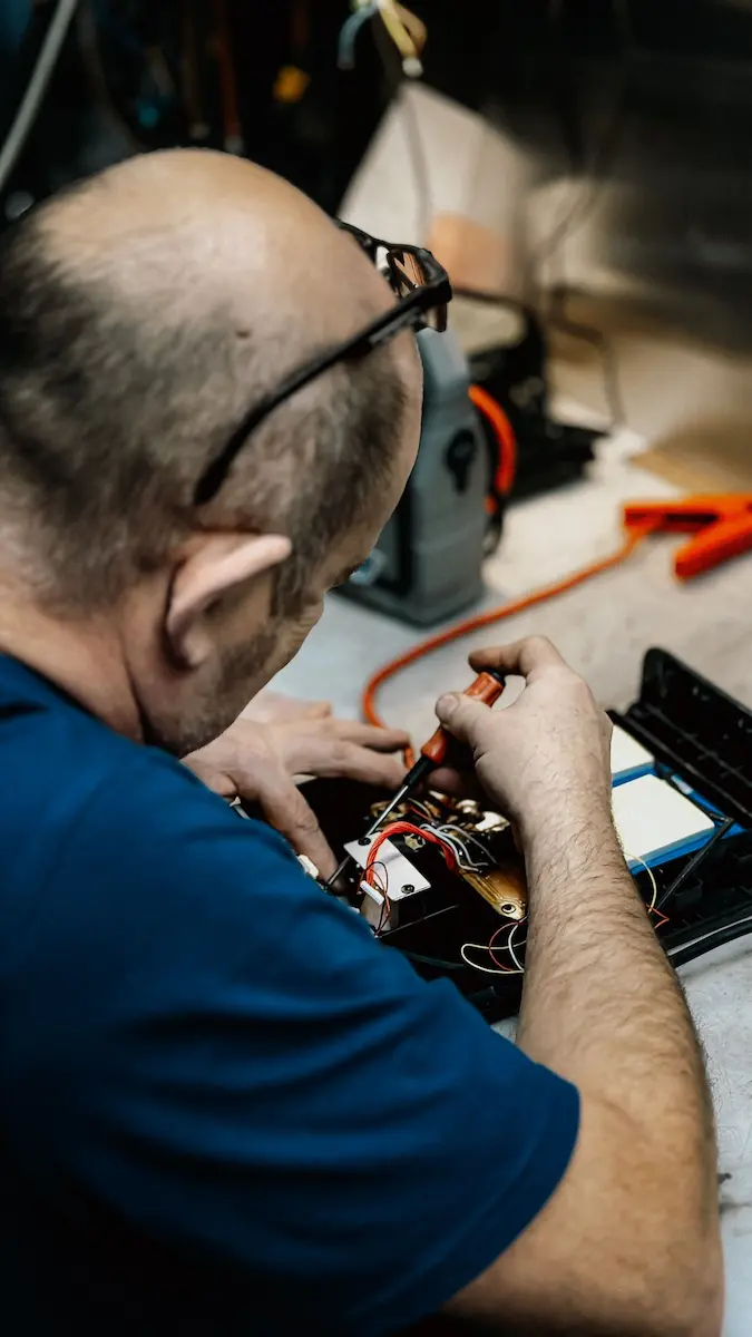 Plumber inspecting and repairing an electronic control component during a home repair