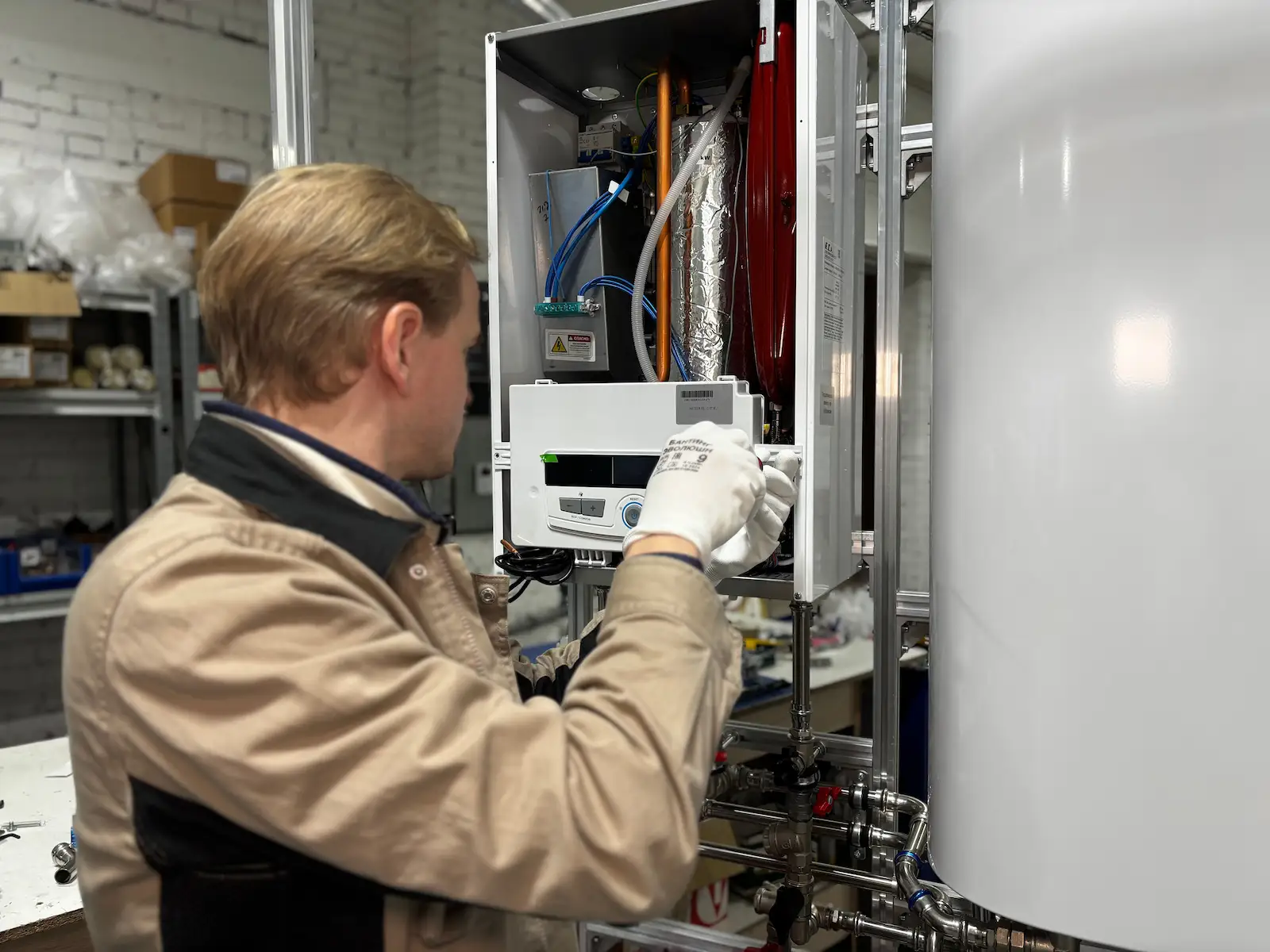 Technician repairing an electric water heater unit and control panel