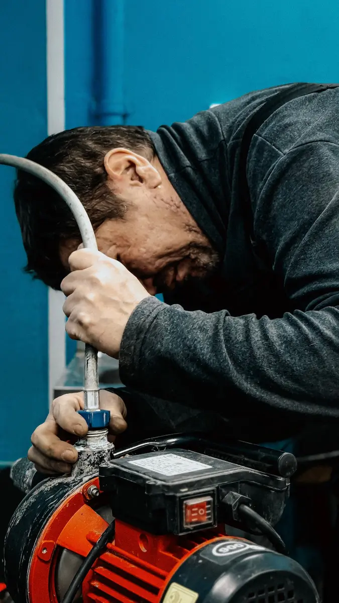 Plumber repairing a water pump motor and pressure valve